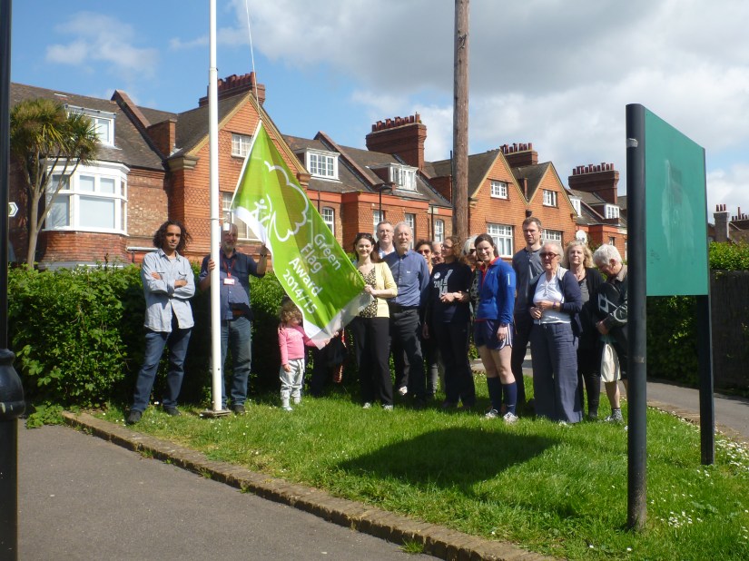 photo of friends and the green flag being raised